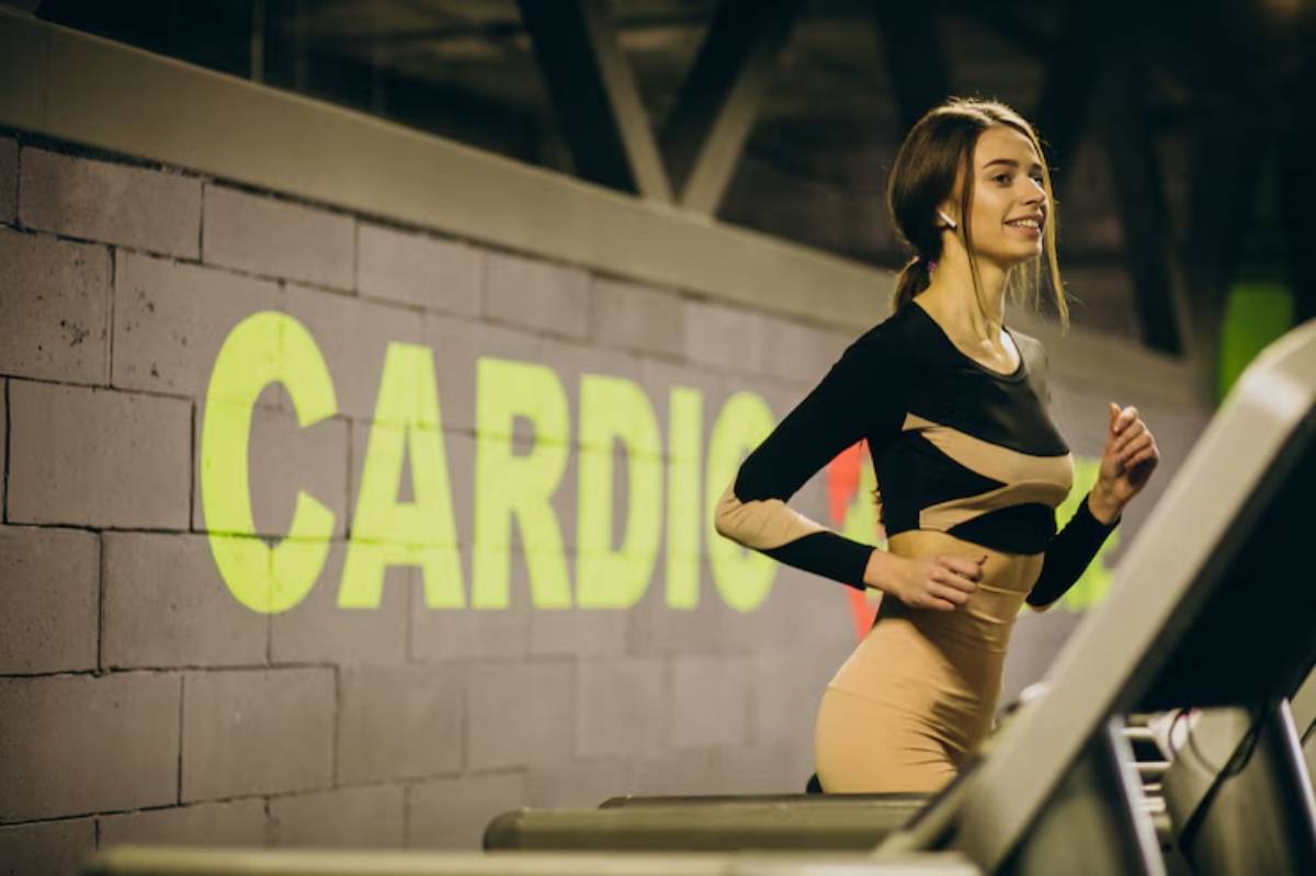  A woman jogging on a treadmill at a gym, smiling and wearing athletic clothing, with the word 